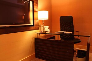 A hotel room with a desk, chair, lamp, and a television mounted on the wall. - Imperial Hotel Miri (Miri)