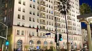 A multi-story hotel with balconies, a street view, and a traffic light. - Luxe Suite one bedroom condo with ocean view balcony and free secure parking (Long Beach)