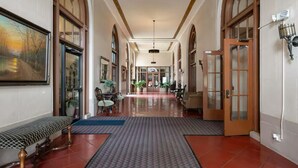 A long hallway with arched windows, a bench, and a patterned rug. - Luxe Suite one bedroom condo with ocean view balcony and free secure parking (Long Beach)
