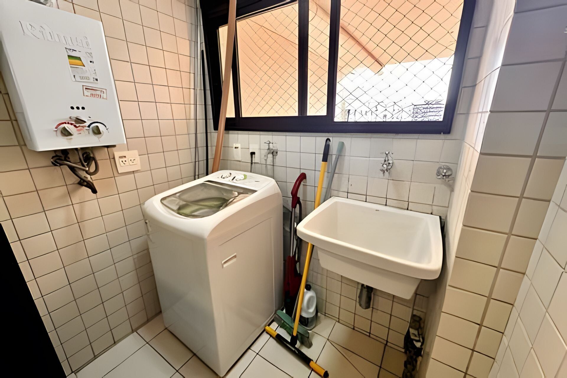 A compact kitchen with a washing machine, a sink, and a window.