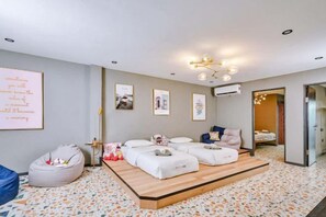 A modern bedroom with a bed, bedside tables, a bean bag, and a large mirror. - Ellys Home (Semporna)