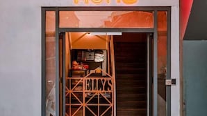 A storefront with a neon sign reading "CHITZ HOME" and a glass door with a geometric pattern. - Ellys Home (Semporna)