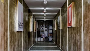 A narrow hallway with a marble floor and wooden walls, leading to a room with shelves and items. - Ellys Home (Semporna)