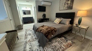 A bedroom with a bed, bedside table, lamp, and a large mirror. - River Ranch condo with Pool (Lafayette)