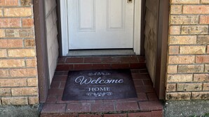A white door with a doormat that reads "Welcome Home." - River Ranch condo with Pool (Lafayette)