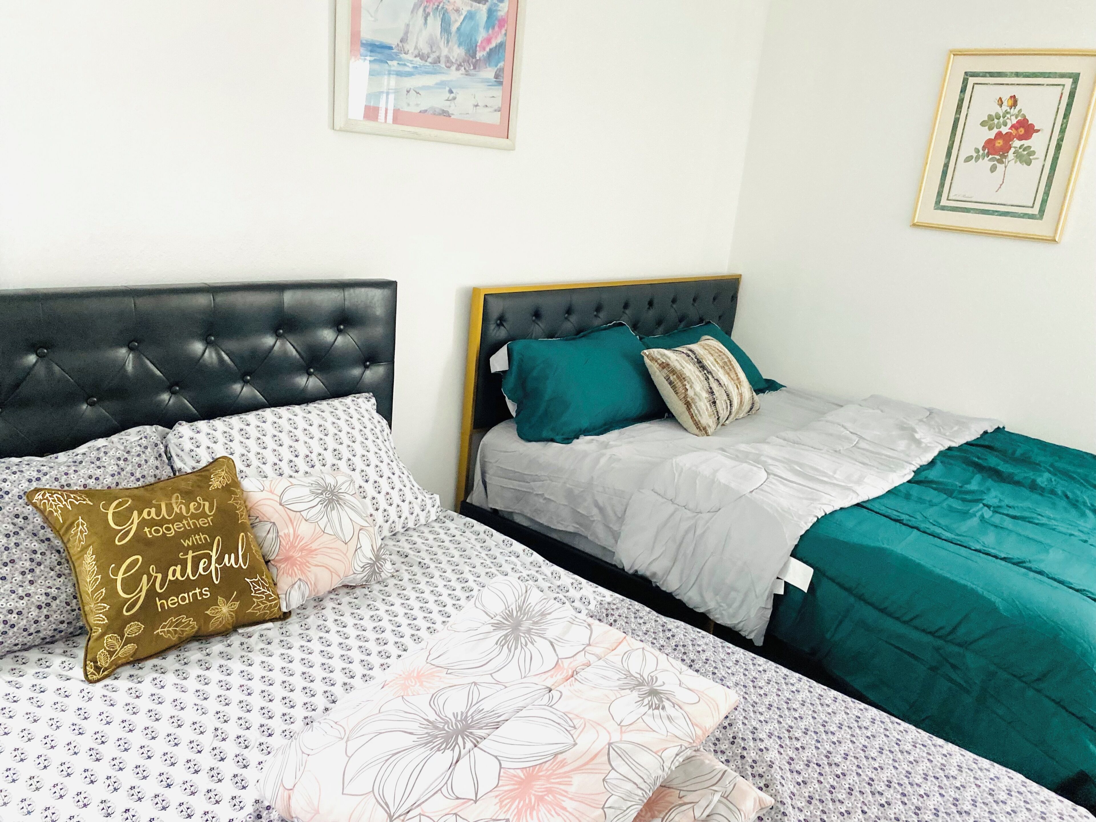 A bedroom with two beds, each with distinct headboards and bedding.