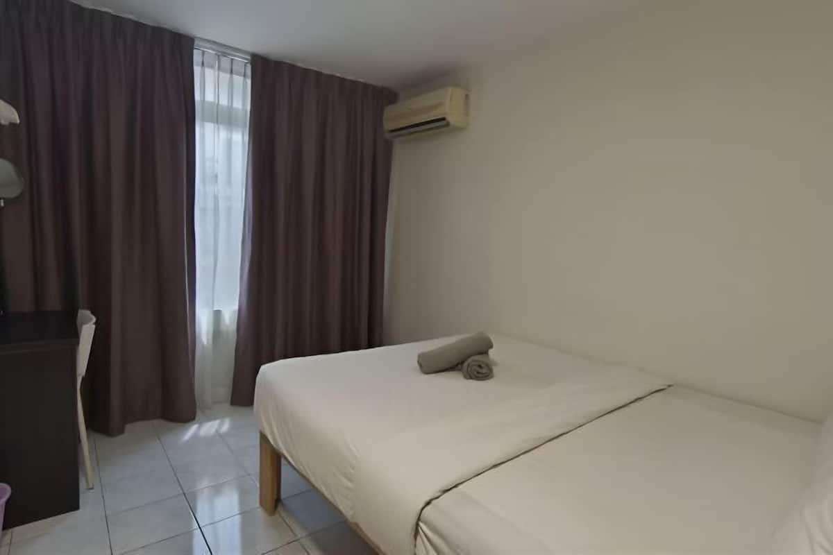 Une chambre d’hôtel équipée d’un lit, d’un bureau, d’une chaise et d’un appareil de climatisation.