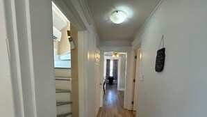 A hallway with wooden flooring, white walls, and a ceiling fan. - Beautiful Downtown Core Apt. Located on Main Street, Kentville (Kentville)