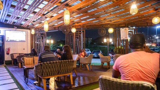 A restaurant with wicker furniture and hanging lights. - Villa Magnum (Douala)