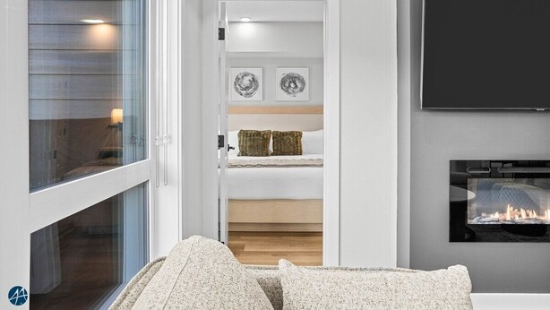 Ein modernes Zimmer mit großem Fenster, Kamin und flachbildschirm-Fernseher an der Wand.