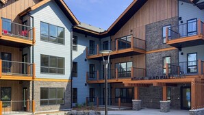 A multi-story building with balconies, a central courtyard, and a sign reading "EAD BUILDING". - 2 Bed/2 Bath Sparrowhawk-1st Floor/East Facing (Dead Man's Flats)