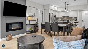A modern living room with a fireplace, a dining area, and a kitchen. - 2 Bed/2 Bath Sparrowhawk-1st Floor/East Facing (Dead Man's Flats)