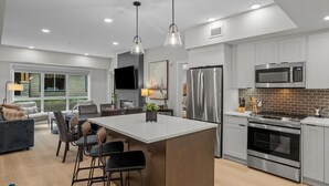 A modern kitchen with a central island, stainless steel appliances, and pendant lighting. - 2 Bed/2 Bath Sparrowhawk-1st Floor/East Facing (Dead Man's Flats)