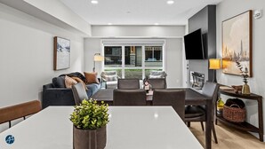 A modern living room with a dining area, a sofa set, a TV, and a fireplace. - 2 Bed/2 Bath Sparrowhawk-1st Floor/East Facing (Dead Man's Flats)
