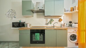 Eine moderne Küche mit Mikrowelle, Backofen, Spüle und Waschmaschine.