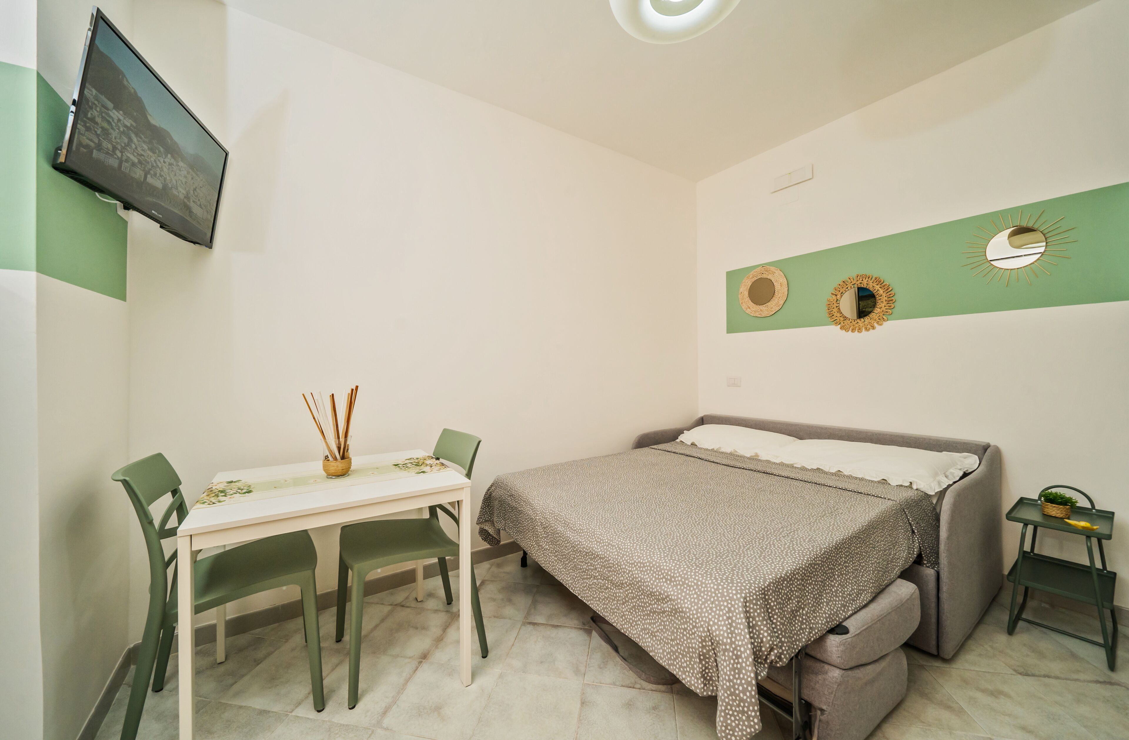 Une petite pièce, bien rangée, avec un lit, un bureau et des chaises.