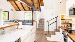 A modern kitchen with white cabinetry, a built-in oven, and a microwave. - Sage House - Walking Distance to Lake, Hot Tub, Pet Friendly w/ New AC (Arnold)