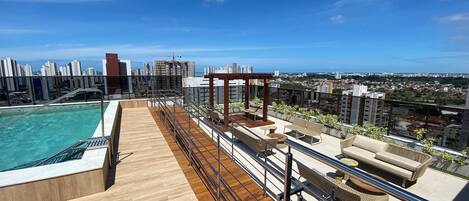 Een buitenzwembad en ligstoelen