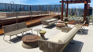A rooftop terrace with outdoor furniture, a pergola, and a city view. - Bela Hospedagem - Compact Time 907 (João Pessoa)