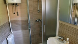 A bathroom with a shower, a sink, and a toilet.