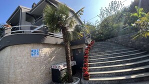 A modern building with a stone facade, a swimming pool sign, and a staircase leading up to a balcony. - Tranquil Spacious Villa with Private Pool - Five Bedroom Villa with Balconies (Matulji)