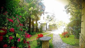 Ein Gartenweg führt zu einem Gebäude mit einem Tor.