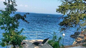 Blick auf die Küste mit einer Treppe, die zum Strand hinunterführt, mit Meerblick.
