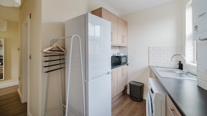 Eine moderne Küche mit Kühlschrank, Mikrowelle, Spüle und Holzschränken.