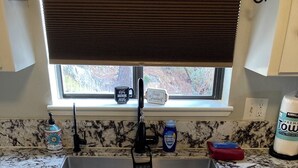 A kitchen with a granite countertop, a stainless steel sink, a window with blinds, and a bottle of dish soap. - 4-Story Lake View Cabin with Boat Slip & Private Marina with Launch Ramp (Bass Lake)