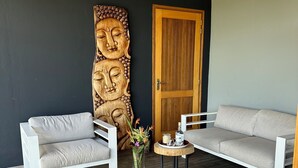 A modern living room with two white sofas, a wooden door, and a decorative wooden sculpture. - 3bed villa, pool, spa and sauna (Lamentin)