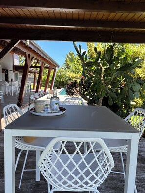 Enjoy al fresco dining under a shaded pergola with a beautifully set table for six.