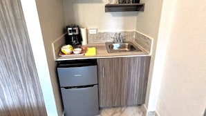 A compact kitchen with a coffee maker, a sink, and a small refrigerator. - El Santuario Estate (Los Naranjos)