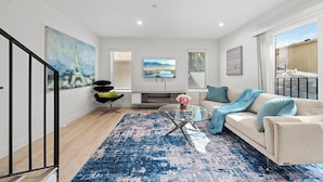 A modern living room with a sofa, coffee table, and artwork on the walls. - Serene Escapes Hollywood  (Los Angeles)