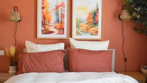 A bedroom with a bed, two wall-mounted lamps, and two framed paintings. - A change of scenery (Poitiers)