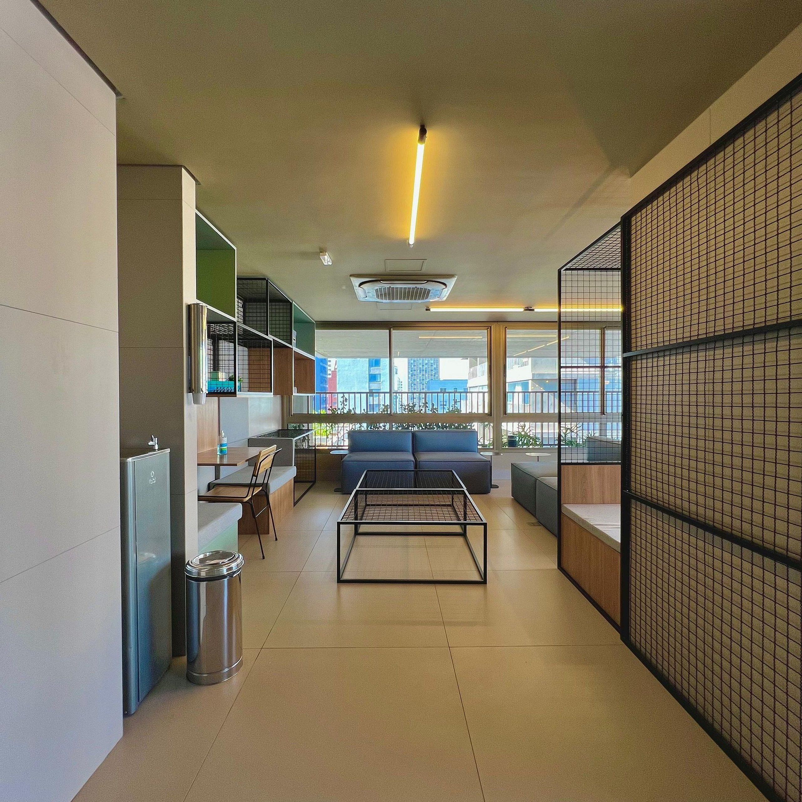 Un intérieur moderne avec un canapé, une table basse et une poubelle.
