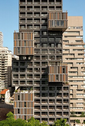 A high-rise building with multiple balconies, a modern architectural design, and a clear sky. - ON MELO ALVES (São Paulo)