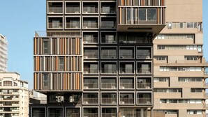 A high-rise building with multiple balconies, a modern architectural design, and a clear sky. - ON MELO ALVES (São Paulo)