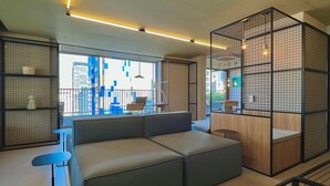 Un interior moderno con un sofá modular, una mesita y una zona de estar con vistas a la ciudad.