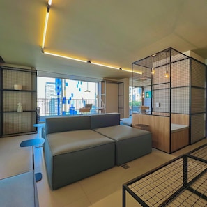 Een modern interieur met een hoekbank, een bijzettafeltje en een zithoek met uitzicht op de skyline.