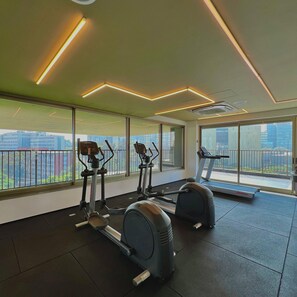 A gym with treadmills, ellipticals, and a stationary bike, large windows with city views, and modern lighting. - ON MELO ALVES (São Paulo)