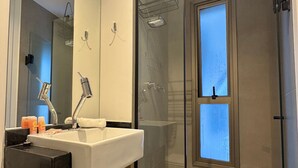 A modern bathroom with a sink, mirror, and shower. - ON MELO ALVES (São Paulo)