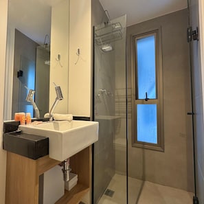 A modern bathroom with a sink, mirror, and shower. - ON MELO ALVES (São Paulo)