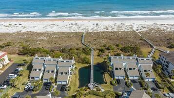 Zona residencial costera con propiedades frente al mar, un puente de conexión y un estacionamiento.