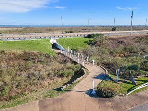 Un ponte pedonale sopra una strada, con vista sull'oceano sullo sfondo.