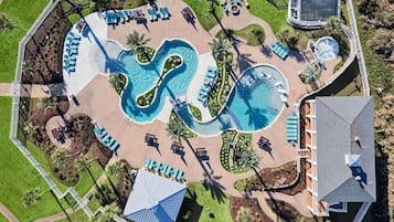 Vue aérienne d’un complexe hôtelier doté d’une grande piscine, de chaises longues et d’un petit bâtiment.