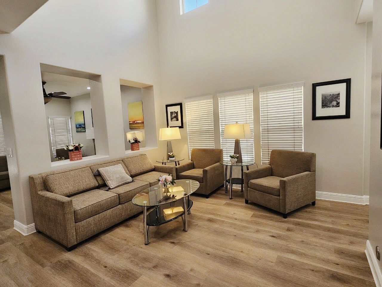 A spacious living room with a large sofa, two armchairs, a coffee table, and a fireplace.