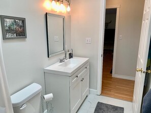 A modern bathroom with a white sink, mirror, and toilet. - Forest Guest Suite Near Picton Centre (Pet-Friendly &Hot Tub &Park Pass)
(Prince Edward)