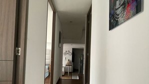 Ein Flur mit Holzboden, der zu einem Essbereich mit Tisch und Stühlen führt.