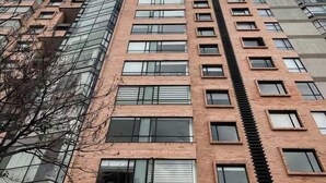 Ein Hochhaus mit mehreren Etagen, das Glas- und Backsteinfassaden kombiniert und eine zentrale Treppe aufweist.
