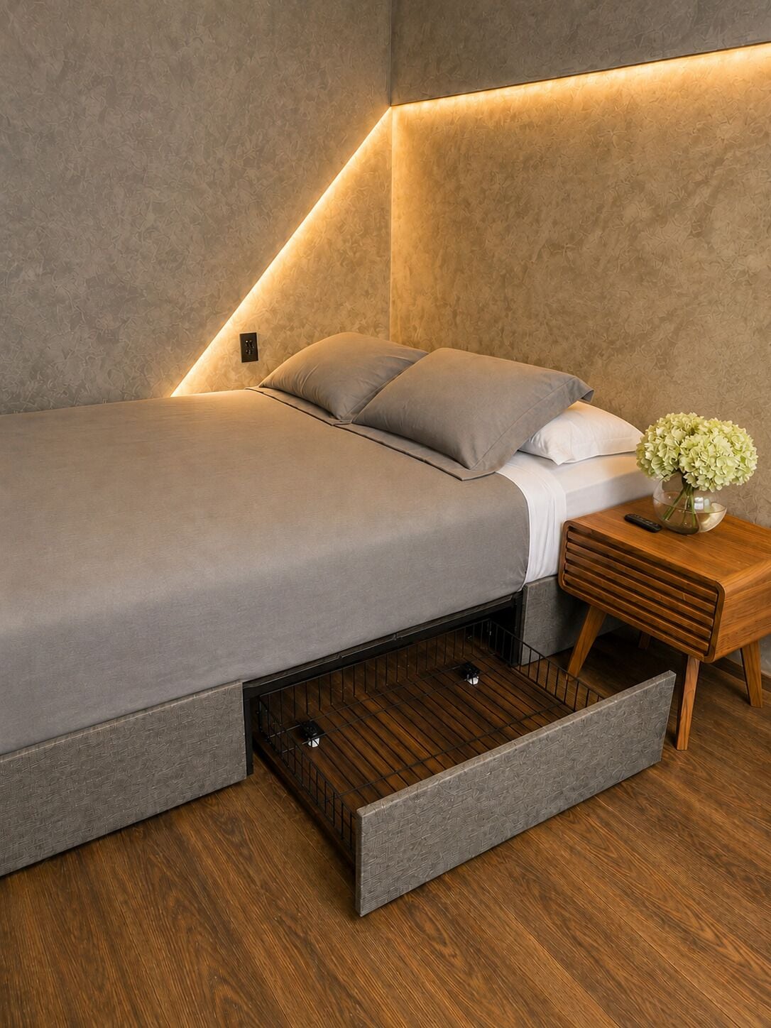 A modern bedroom with a bed, a nightstand, and a small table with a vase.